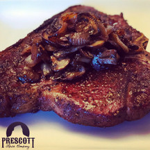T-Bone steak reverse seared topped with caramelized mushrooms and onions. This steak is incredible as it combines the wonderful NY strip coming from the short loin with the filet coming from the tenderloin. Doesn't get much better than this! Start by seasoning you steak several days prior to the cook. We like to use smoked salt and black pepper. On the day of the cook, pull out of refrigerator 1-2 hours before cooking. Heat a cast iron skillet on high. With just a touch of oil, sear each side for no more than a minute. Allow steak to rest for 15 minutes. Place steak in an oven set to 225º with a probe thermometer inserted. When desired doneness is reached, pull out and allow to rest for 10-15 minutes. Caramelized onions and mushroom recipe can be found with the other recipes on our website.